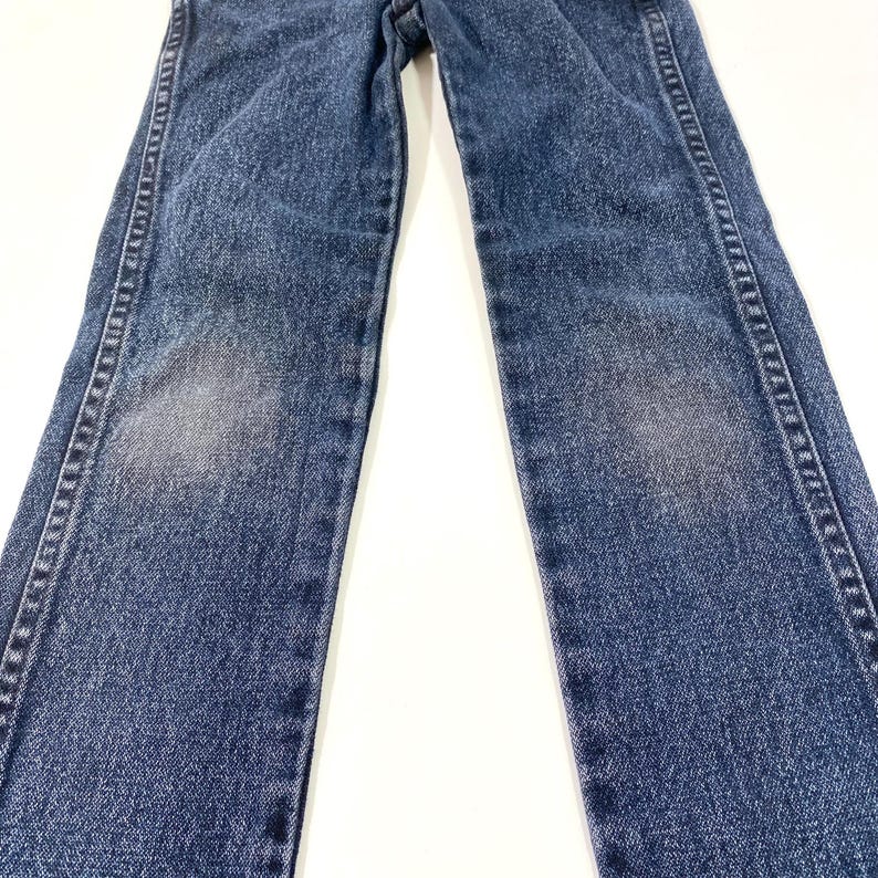 Może przedstawiać: Dżinsy z niebieskiego denimu o prostym kroju nogawek. Dżinsy mają wyblakły wygląd i są wykonane z miękkiego, wygodnego materiału.