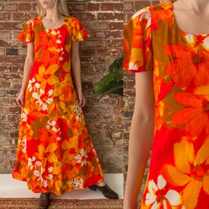 Könnte beinhalten: Ein langes, orangefarbenes, gelbes und weißes Maxikleid mit floralem Muster und kurzen, glockenförmigen Ärmeln. Das Kleid hat einen runden Ausschnitt und einen taillierten Oberteil.