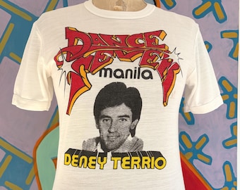 Camiseta vintage de los años 70 con estampado de Deney Terrio Dance Fever, con ribetes promocionales - Costura sencilla (talla XS: 42 x 62 cm)