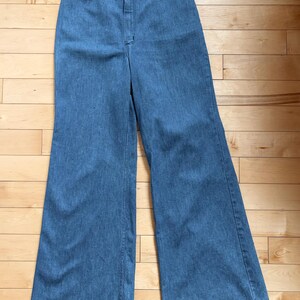 Puede incluir: Pantalones vaqueros azul claro con dise&ntilde;o de pernera ancha. Los pantalones tienen cierre de bot&oacute;n y cremallera en la cintura y un dise&ntilde;o cl&aacute;sico de cinco bolsillos. Los pantalones est&aacute;n hechos de tela vaquera de peso medio.