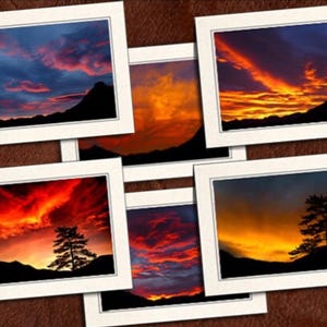 May include: A collection of framed landscape photographs featuring vibrant sunsets. Each image showcases a different fiery sky with shades of orange, red, and blue, silhouetting mountains and trees. The frames are white, set against a brown background.