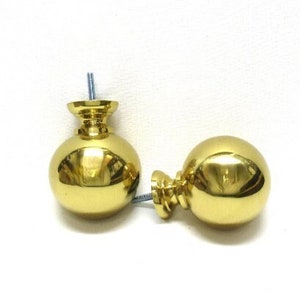 May include: Two gold-toned round cabinet knobs with a smooth, shiny finish. The knobs have a small, round base and a screw hole for installation.