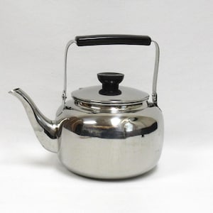 May include: A stainless steel tea kettle with a black handle and lid knob. The kettle has a curved spout and a handle that arches over the top. The polished metal reflects the surrounding environment. A classic kitchenware item.