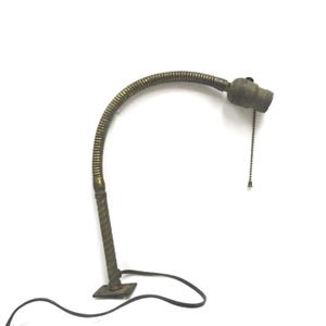 May include: An antique brass desk lamp with a flexible, ribbed neck and a twisted base. The lamp has a pull chain and a black electrical cord. The lamp is set against a white background.