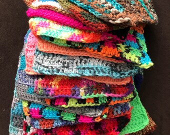 May include: A stack of colorful crocheted squares in various patterns and colors, including blue, green, pink, orange, and red.