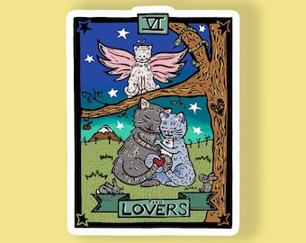May include: A sticker featuring a tarot card design with two cats embracing, a winged cat, and the word "LOVERS." The card has a night sky background with stars and a tree. The sticker is on a yellow background.