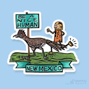 May include: A sticker featuring a roadrunner with a robot, a sign that reads "BE A NICE HUMAN", and a banner that says "NEW MEXICO". The roadrunner is brown and black, and the robot is orange. The sticker has a blue background.