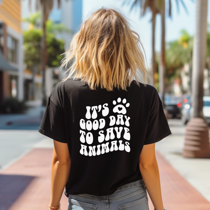 May include: A black t-shirt with a white paw print and the text "It's a good day to save animals" in a retro font.