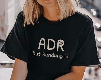 May include: Black t-shirt with the text "ADR but handling it" in white with a paw print in the "R".