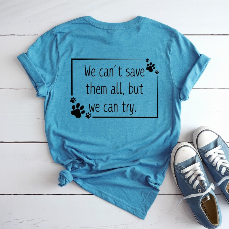 May include: A turquoise blue t-shirt with the text "We can't save them all, but we can try." in a black box with paw prints around the text.