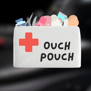 May include: White canvas pouch with a red cross and the text "OUCH POUCH". The pouch is filled with various first aid supplies, including bandages, gauze, and a small bottle.