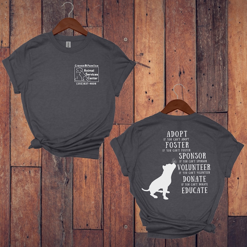 May include: Gray t-shirt with a white graphic on the front that says "Craven Pamlico Animal Services Center (252)637-4606". The back of the shirt has a white graphic of a dog with the text "Adopt if you can't adopt, Foster if you can't foster, Sponsor if you can't sponsor, Volunteer if you can't volunteer, Donate if you can't donate, Educate".