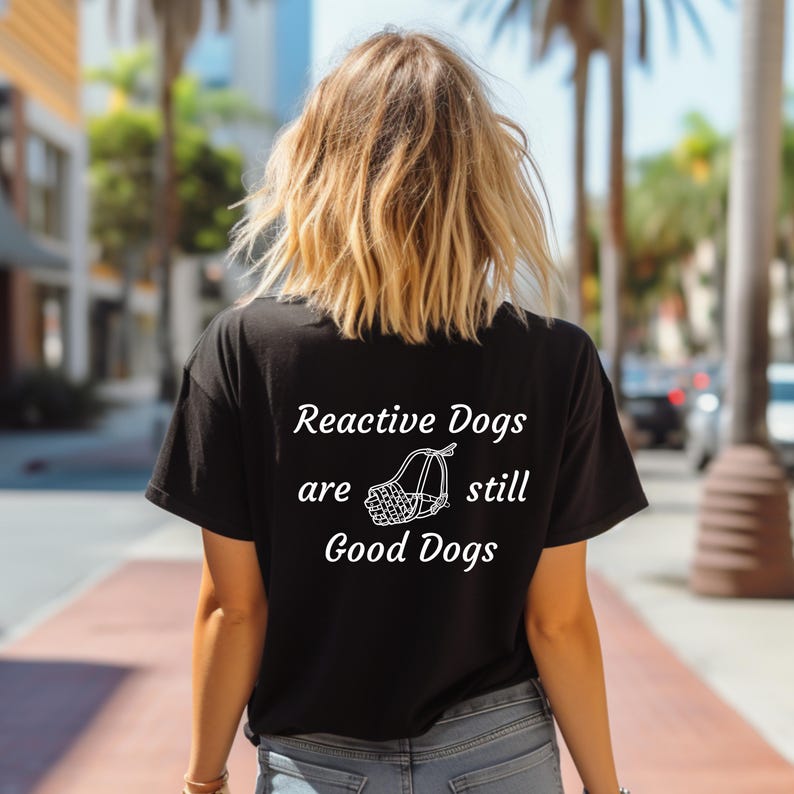 May include: Black t-shirt with white text that reads "Reactive Dogs are still Good Dogs" and a white illustration of a dog muzzle.
