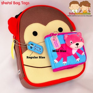 May include: Two metal bag tags with a monkey backpack. The larger tag is labeled "Jerry Smith" and the smaller tag is labeled "Sophia Smith". The tags are attached to the backpack with a chain and a key ring.