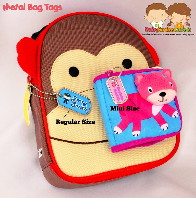 May include: Two metal bag tags with a monkey backpack. The larger tag is labeled "Jerry Smith" and the smaller tag is labeled "Sophia Smith". The tags are attached to the backpack with a chain and a key ring.
