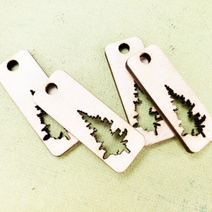 May include: Four unfinished wooden tags with a cutout of a fir tree. The tags have a hole at the top for hanging.