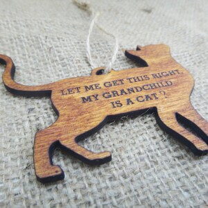 May include: Wooden cat ornament with the text "Let me get this right, my grandchild is a cat?"