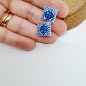 K&ouml;nnte beinhalten: Ein Paar blaue und wei&szlig;e Keramikfliesen-Ohrringe. Die Fliesen haben ein blaues und wei&szlig;es Blumenmuster.