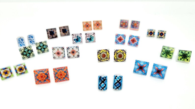 K&ouml;nnte beinhalten: Ein Set mit 12 Paaren bunter quadratischer Fliesenohrringe mit verschiedenen geometrischen Mustern. Die Ohrringe sind aus Harz gefertigt und haben eine gl&auml;nzende Oberfl&auml;che.