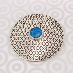 Handmade brooch made from Sterling Silver and featuring a blue Opal gemstone and a circle pattern, round and slightly domed, stone choice