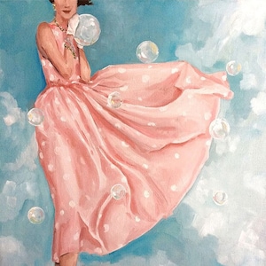 May include: A woman in a pink polka dot dress blows bubbles in a blue sky with white clouds. The dress is flowing in the wind and the bubbles are floating around her.