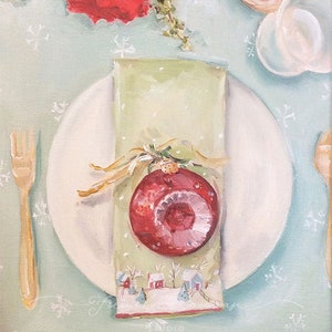 Peut inclure: Une mise en place de No&euml;l festive avec une assiette blanche, une fourchette dor&eacute;e et une serviette verte orn&eacute;e d'une boule rouge. La serviette est nou&eacute;e avec un ruban dor&eacute; et pr&eacute;sente une sc&egrave;ne de village d'hiver. Des poinsettias rouges et une tasse en verre sont en arri&egrave;re-plan.