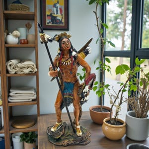 May include: A detailed figurine of a Native American warrior, holding a spear and shield. The figure is painted with vibrant colours, including red, blue, and yellow, and stands on a rocky base. The warrior is adorned with traditional headdress and clothing.