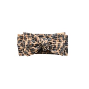May include: A brown and black leopard print knotted headband.