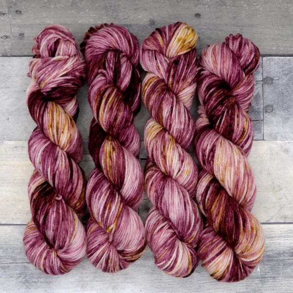 Mulled Wine (Worsted Merino, variegated) - deep and varying shades of cranberry with splashes of gold