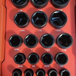 May include: A red plastic case with a variety of black socket wrenches. The case has a label that says "PACT RATED", "IP65 RATED PROTECTION", and "NO TRAVEL BIN SEALS".
