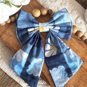 May include: A large blue and white bow with a floral pattern. The bow is made of fabric and has a yellow center.