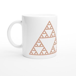 May include: White ceramic mug featuring a brown geometric pattern of a Sierpinski triangle. The pattern is a fractal design with a repeating triangle shape.