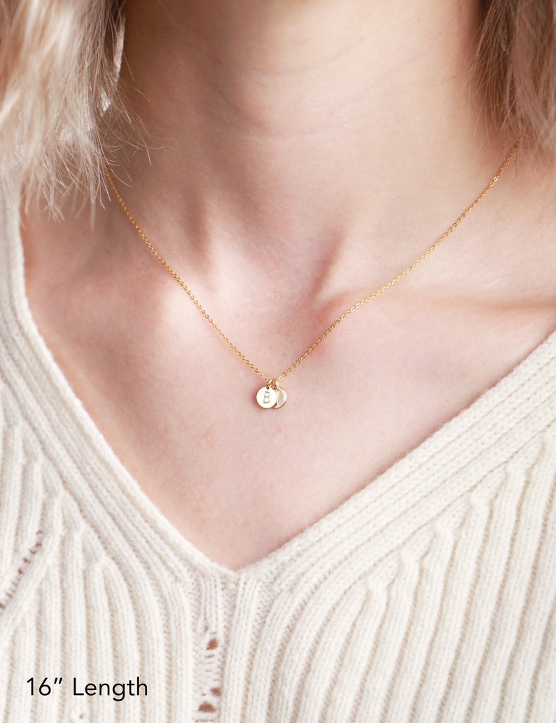 May include: A gold chain necklace with two small gold discs, each with a letter 'B' engraved on it. The necklace is 16 inches long.