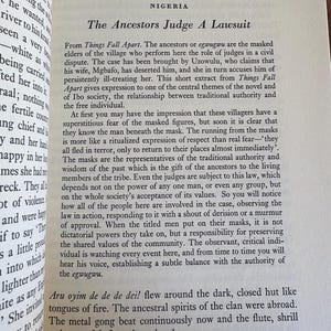 Pu&ograve; includere: Pagina di libro aperta con testo di Chinua Achebe, intitolato "The Ancestors Judge A Lawsuit". Il testo &egrave; in inglese, incentrato sui temi della tradizione e dell'autorit&agrave; all'interno di una comunit&agrave;.