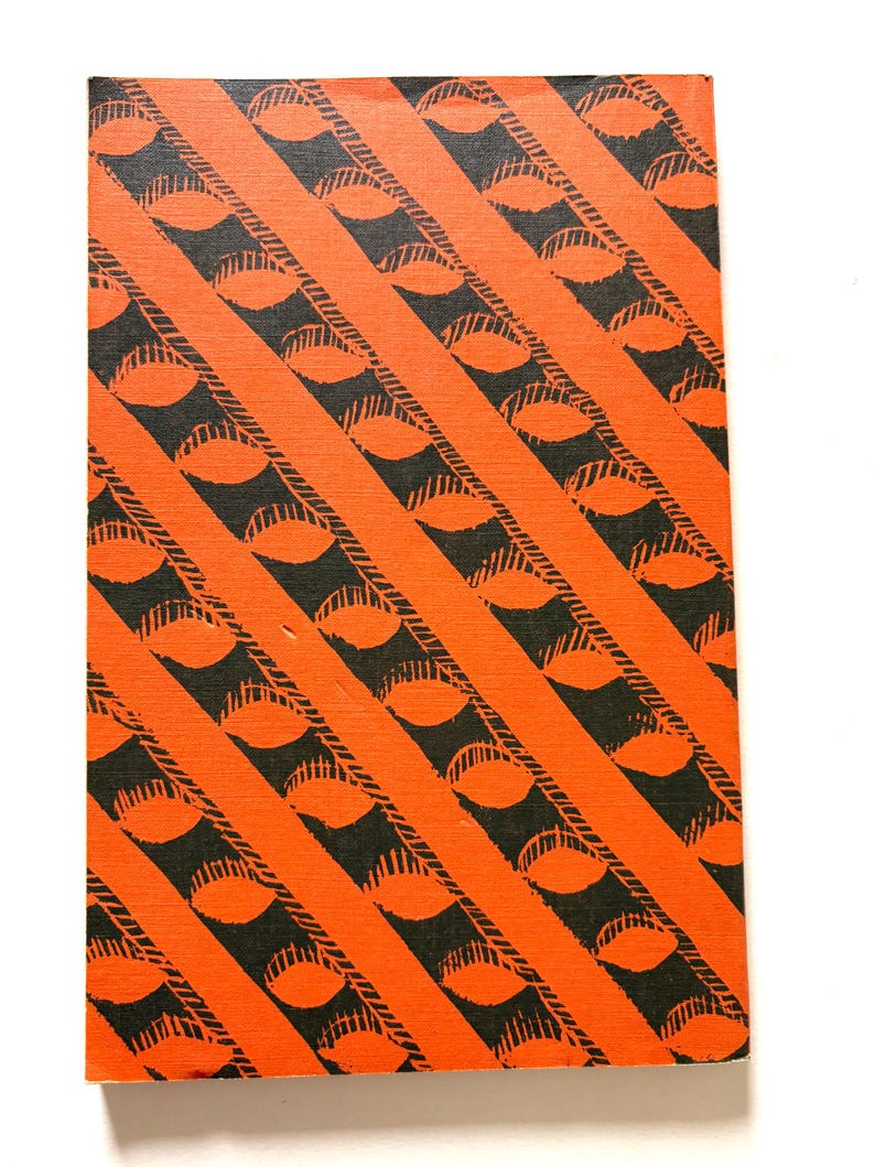 Pu&ograve; includere: Un oggetto rettangolare con un motivo ripetuto di disegni neri a forma di occhio all'interno di strisce diagonali arancioni. Il design copre l'intera superficie, creando un effetto visivo audace e grafico.