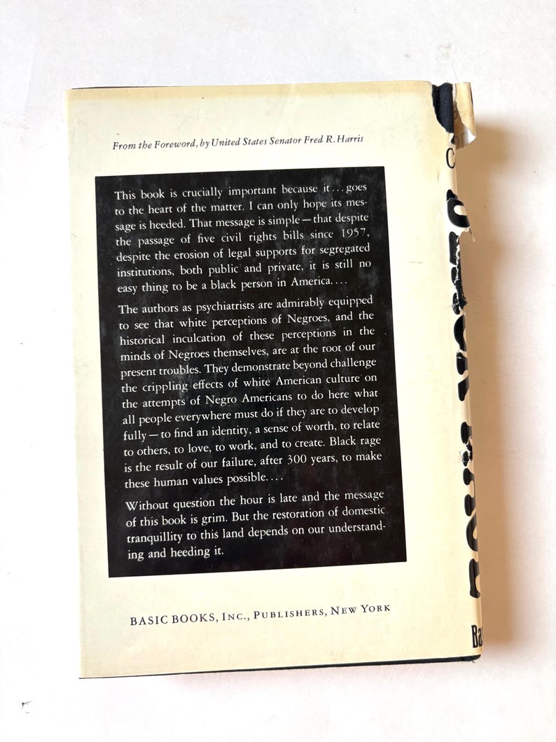 K&ouml;nnte beinhalten: Ein Vintage-Buch mit wei&szlig;em und schwarzem Einband. Die R&uuml;ckseite des Einbands enth&auml;lt einen Text aus dem Vorwort von US-Senator Fred R. Harris. Titel und Autor des Buches sind nicht sichtbar. Das Buch ist leicht abgenutzt.