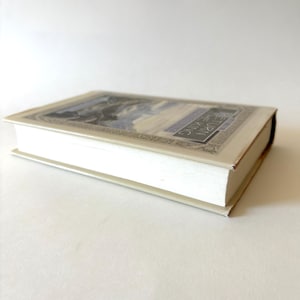 May include: A hardcover book with a cream-colored cover and pages. The book's cover features a detailed illustration with blue and gray tones, and the title "RETURN THE KING" is visible. The book is lying flat on a white surface.