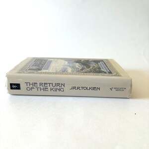 May include: A hardcover book titled "The Return of the King" by J.R.R. Tolkien. The book has a cream-colored cover with the title in dark blue and a detailed illustration. The publisher's logo is visible.