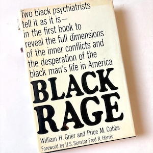 K&ouml;nnte beinhalten: Ein Vintage-Taschenbuch mit dem Titel "BLACK RAGE" von William H. Grier und Price M. Cobbs. Das Cover ist cremefarben mit schwarzem Text, einschlie&szlig;lich des Titels in gro&szlig;en, fetten Buchstaben. Das Buch behandelt das Leben schwarzer M&auml;nner in Amerika.