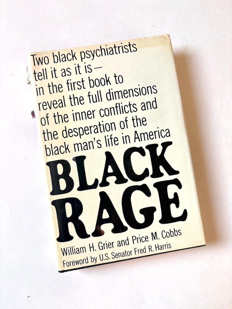 K&ouml;nnte beinhalten: Ein Vintage-Taschenbuch mit dem Titel "BLACK RAGE" von William H. Grier und Price M. Cobbs. Das Cover ist cremefarben mit schwarzem Text, einschlie&szlig;lich des Titels in gro&szlig;en, fetten Buchstaben. Das Buch behandelt das Leben schwarzer M&auml;nner in Amerika.