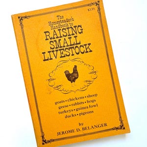 May include: A vintage book titled "The Homesteader's Handbook to Raising Small Livestock" with a yellow cover. The cover features a rooster illustration and lists various livestock. The author's name is Jerome D. Belanger.