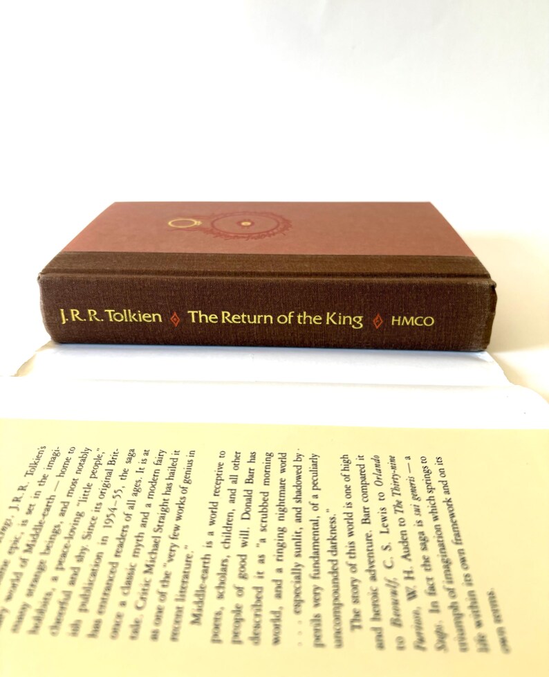 May include: A hardcover edition of "The Return of the King" by J.R.R. Tolkien. The book has a brown cover with gold lettering and a circular design. The title and author's name are visible.