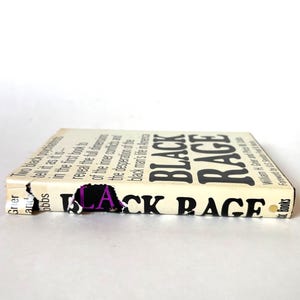 K&ouml;nnte beinhalten: Ein Vintage-Buch mit dem Titel "Black Rage" und einem besch&auml;digten Einband. Der Titel des Buches ist in fetten schwarzen Buchstaben auf cremefarbenem Hintergrund. Der Buchr&uuml;cken ist sichtbar, mit Text und Autorennamen.