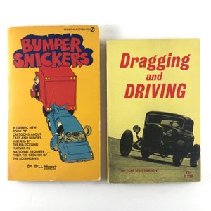 May include: Two paperback books about cars. The book on the left is titled "Bumper Snickers" and features a cartoon illustration of a car being rear-ended. The book on the right is titled "Dragging and Driving" and features a black and white photo of a hot rod.