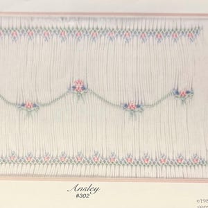 May include: A white fabric panel with a delicate floral embroidery design. The embroidery features pink, blue, and green floral patterns. The word "Ansley" and the number "#302" are printed at the bottom.