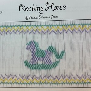May include: A white fabric panel with a smocked design featuring a rocking horse in green and purple. The text "Rocking Horse" and "Easy to Smock" are visible.