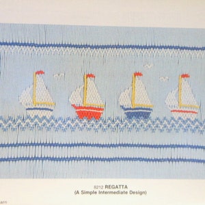 May include: A light blue fabric panel featuring an embroidered regatta design. Four sailboats with white sails, red, yellow, and blue accents, and red flags sail on blue and white waves. The text "REGATTA" is below the design.