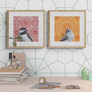 May include: Two framed prints with a bird on each. The print on the left has a red and white patterned background with a black-headed chickadee. The print on the right has an orange and yellow patterned background with a tufted titmouse.