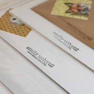 May include: Stack of white cards with the text "emily uchytil" and the website address "www.emilyuchytil.com" printed on each card.