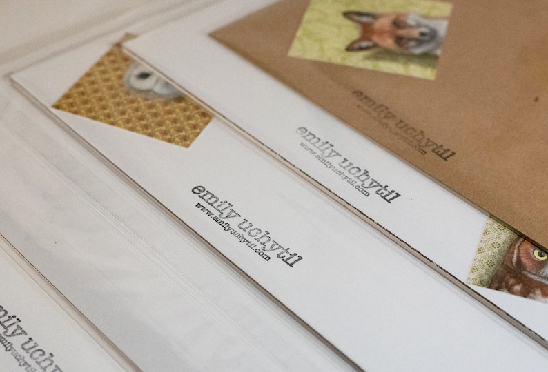 May include: Stack of white cards with the text "emily uchytil" and the website address "www.emilyuchytil.com" printed on each card.